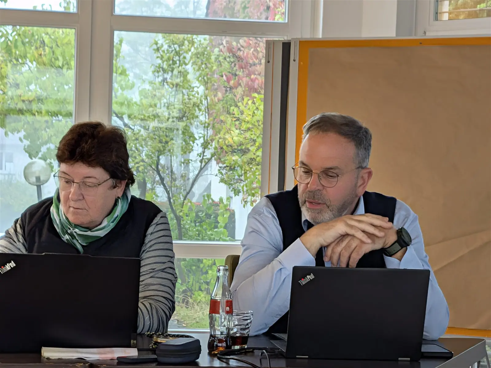 Zwei Teilnehmende am Tisch mit ihren Laptops